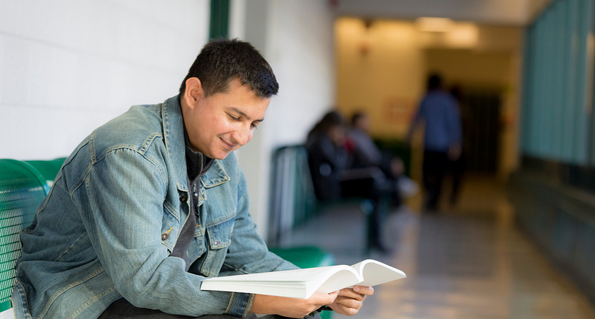 picture of a Centennial College School of Advancement Part-time Learning program student in the hall reading a book